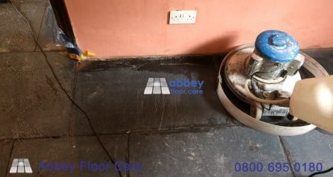 Old paint and coating residue on a scrubbed riven slate floor